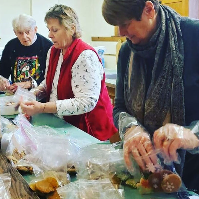 Missions ladies filling bags with cookies